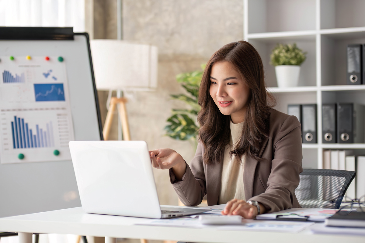 cheerful business lady working on laptop in office